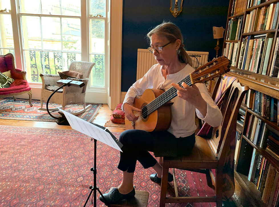 Classical guitar resting in a sunlit studio