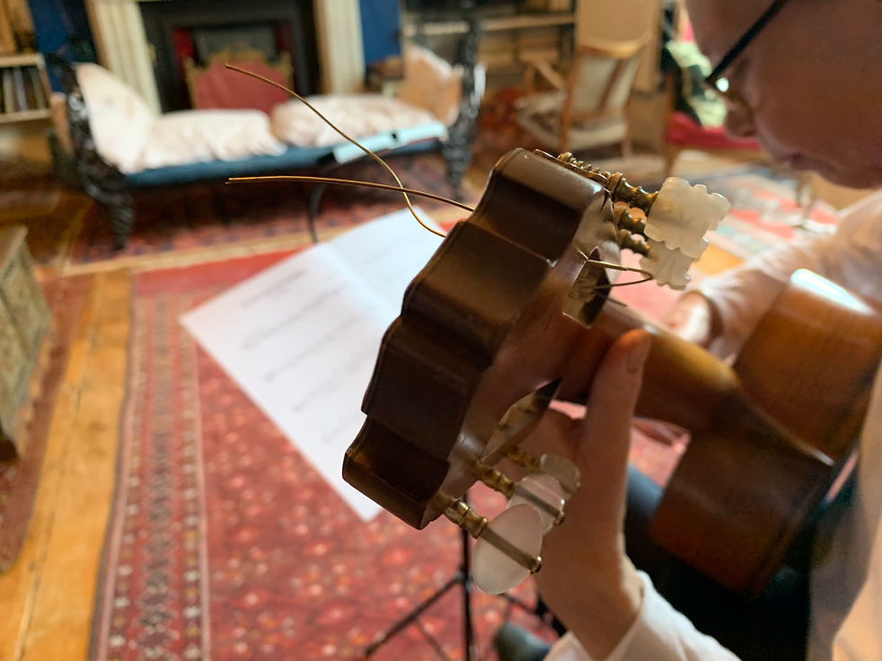 Classical guitar resting in a sunlit studio